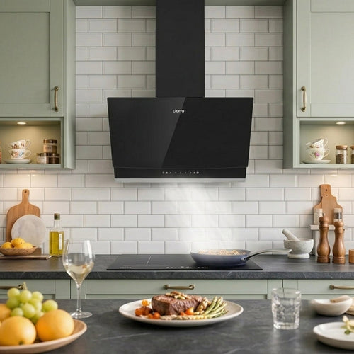 Black Ciarra angled range hood extracting steam in a sage green kitchen.