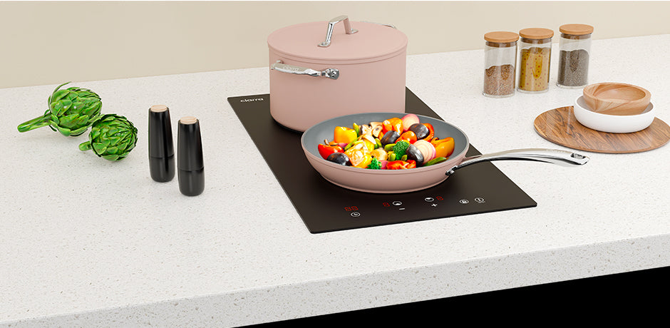 ceramic cooktop with a pan of vegetables on a kitchen counter
