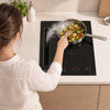 Home chef cooking on black 39cm Ciarra CBBEH3952-2B downdraft induction hob with integrated extractor