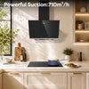A modern black glass CIARRA cooker hood mounted above a black induction cooktop in a bright, sunlit kitchen. Spanish text at the top reads 'Potente succion: 650m³/h'.