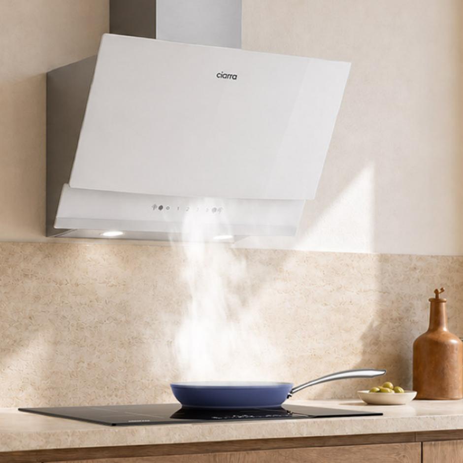 White 60cm angled wall-mounted CIARRA CBCW6736A cooker hood, featuring angled cooker hood design, 710 m³/h extraction rate, ducted & recirculating ventilation modes, used for fume extraction during high-heat home kitchen stir-frying