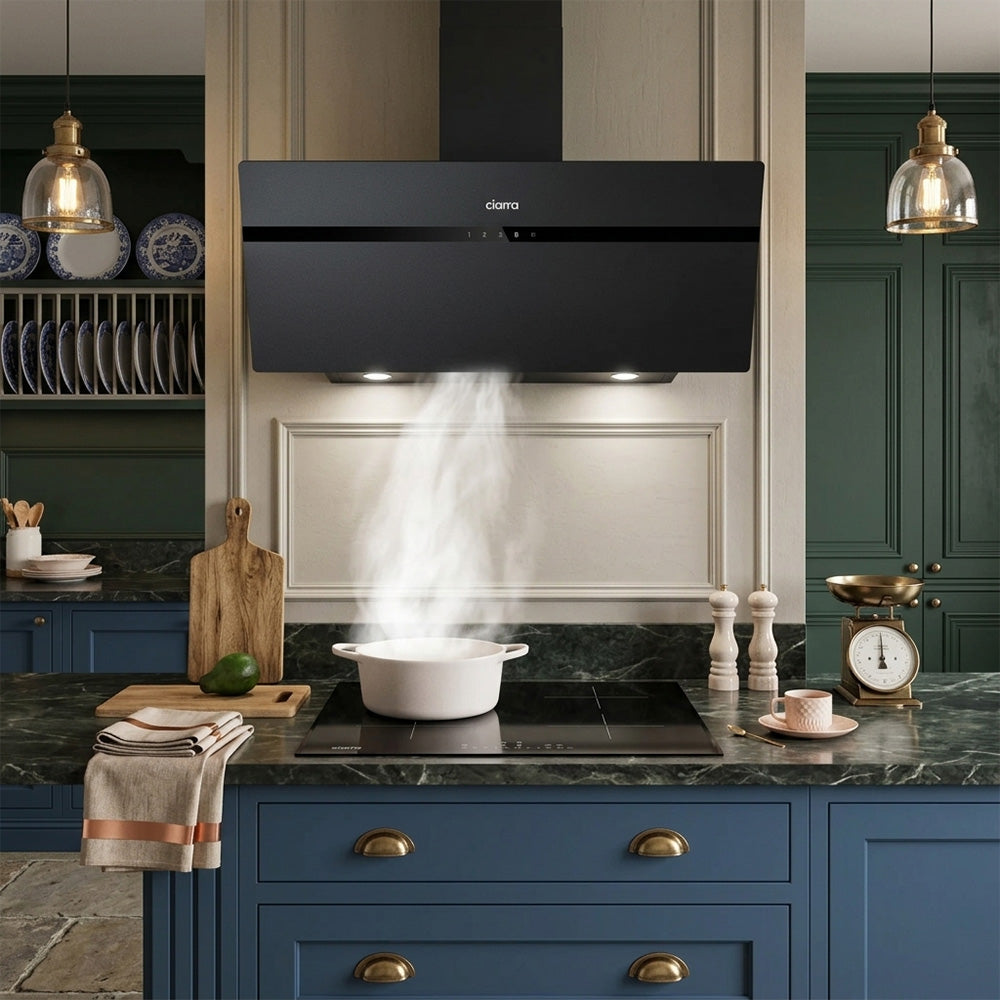 Ciarra UK 90cm black slant range hood efficiently extracting steam from a pot, modern kitchen setup.